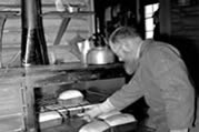 Brother R.Mahé, OMI, baking bread. Colville Lake, NWT, 1964. (N-2001-002-3309)