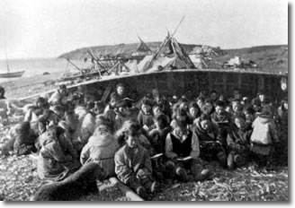 An Anglican Church service in the shelter of an upturned boat, circa 1900