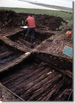 Déblaiement des vestiges d'une maison en bois de grève et en terre à Kuukpak